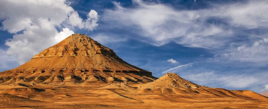 Desert rock formations beneath dramatic clouds at Bahariya