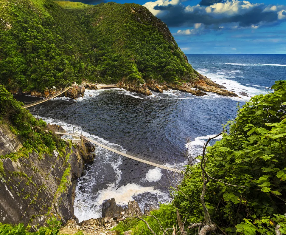 Suspension bridge crossing a rocky coastal inlet